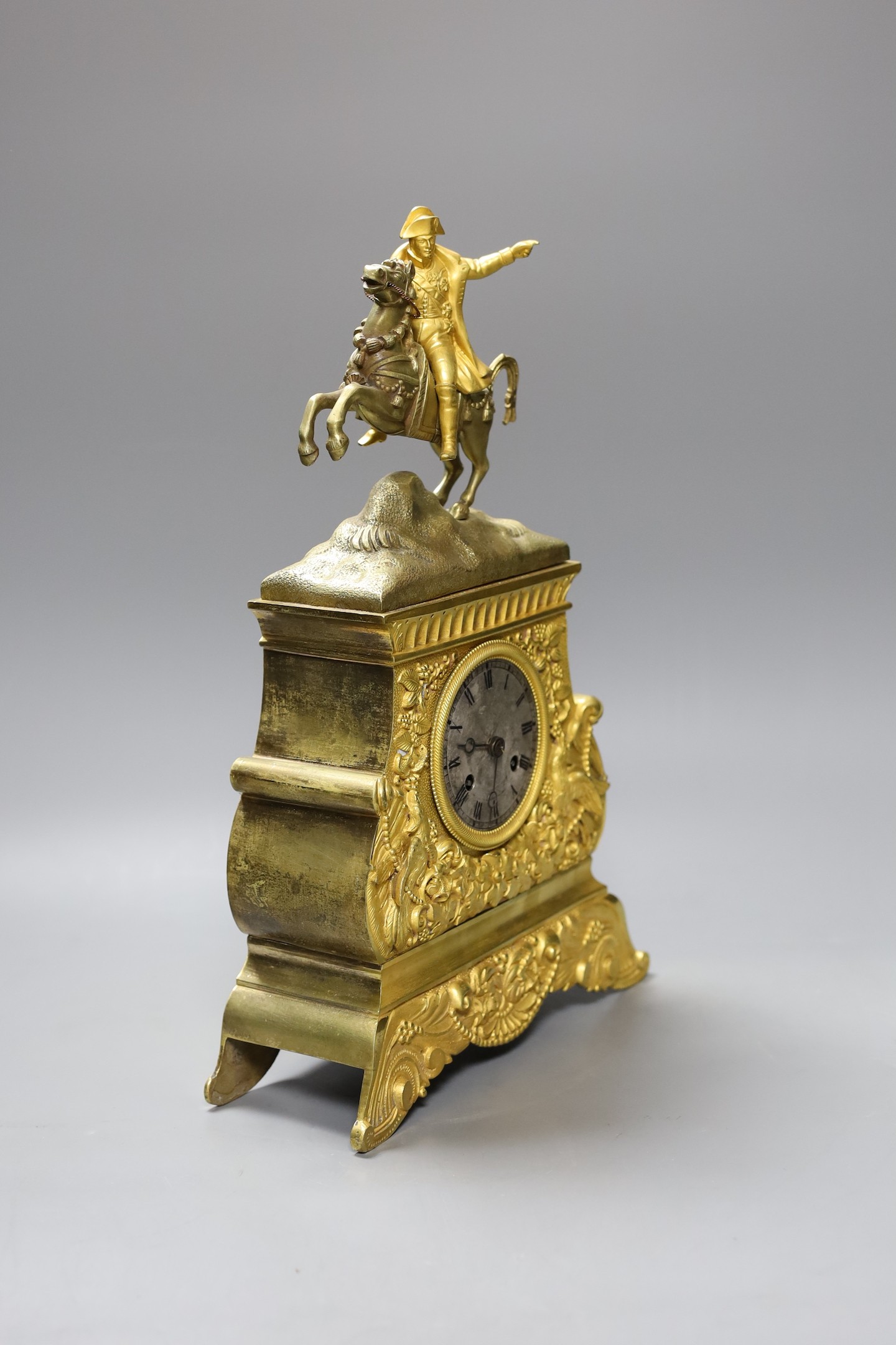 A French ormolu silk suspension clock depicting Napoleon on horseback, with pendulum, 36cm tall